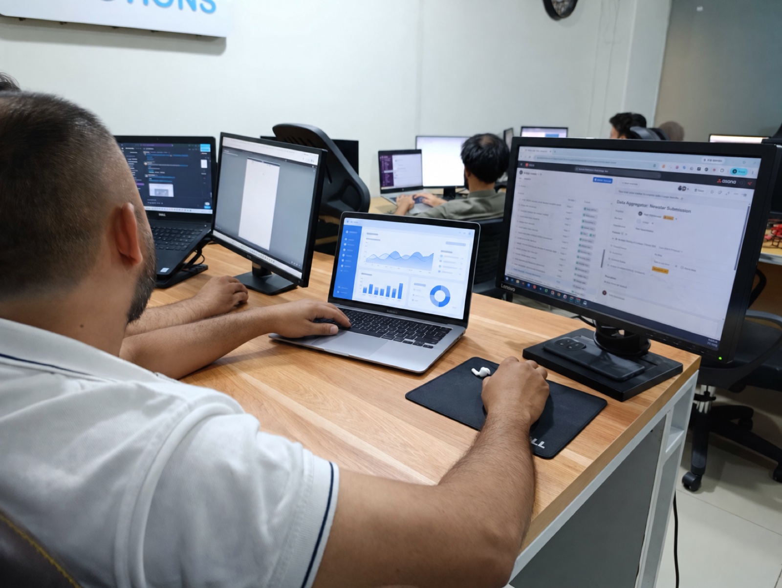 Vital Web Solution employee working at a desk with a laptop and monitor